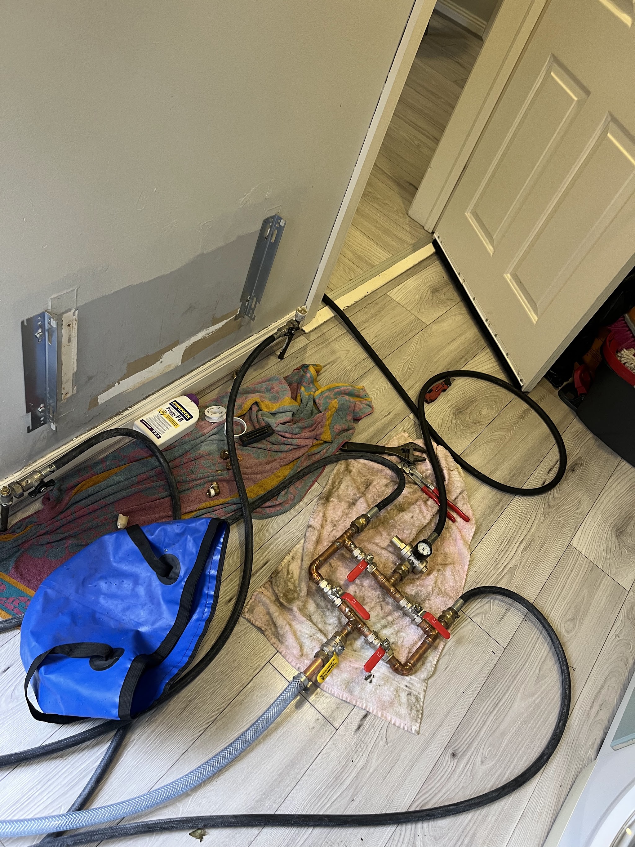 Valve manifold and hoses set up to flush a heating system next to a radiator bracket